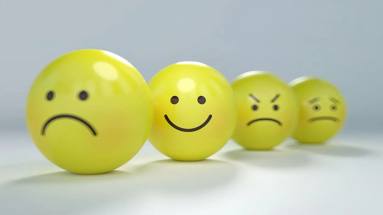 Four yellow spheres with varying facial expressions representing different emotions like sadness, happiness, anger, and worry.