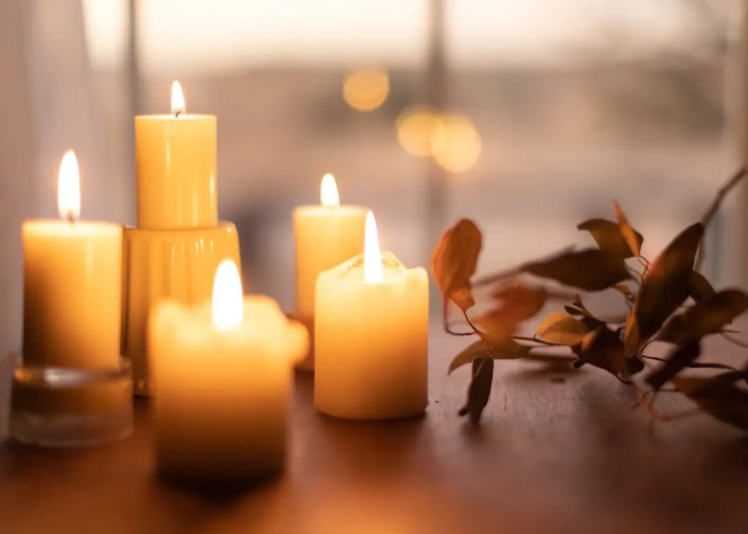Warm ambiance with lit candles and leaves, representing emotional balance and inner peace.