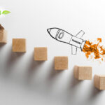 growth Wooden blocks arranged as steps with a small plant sprout and a hand‑drawn rocket symbolising growth and progress.